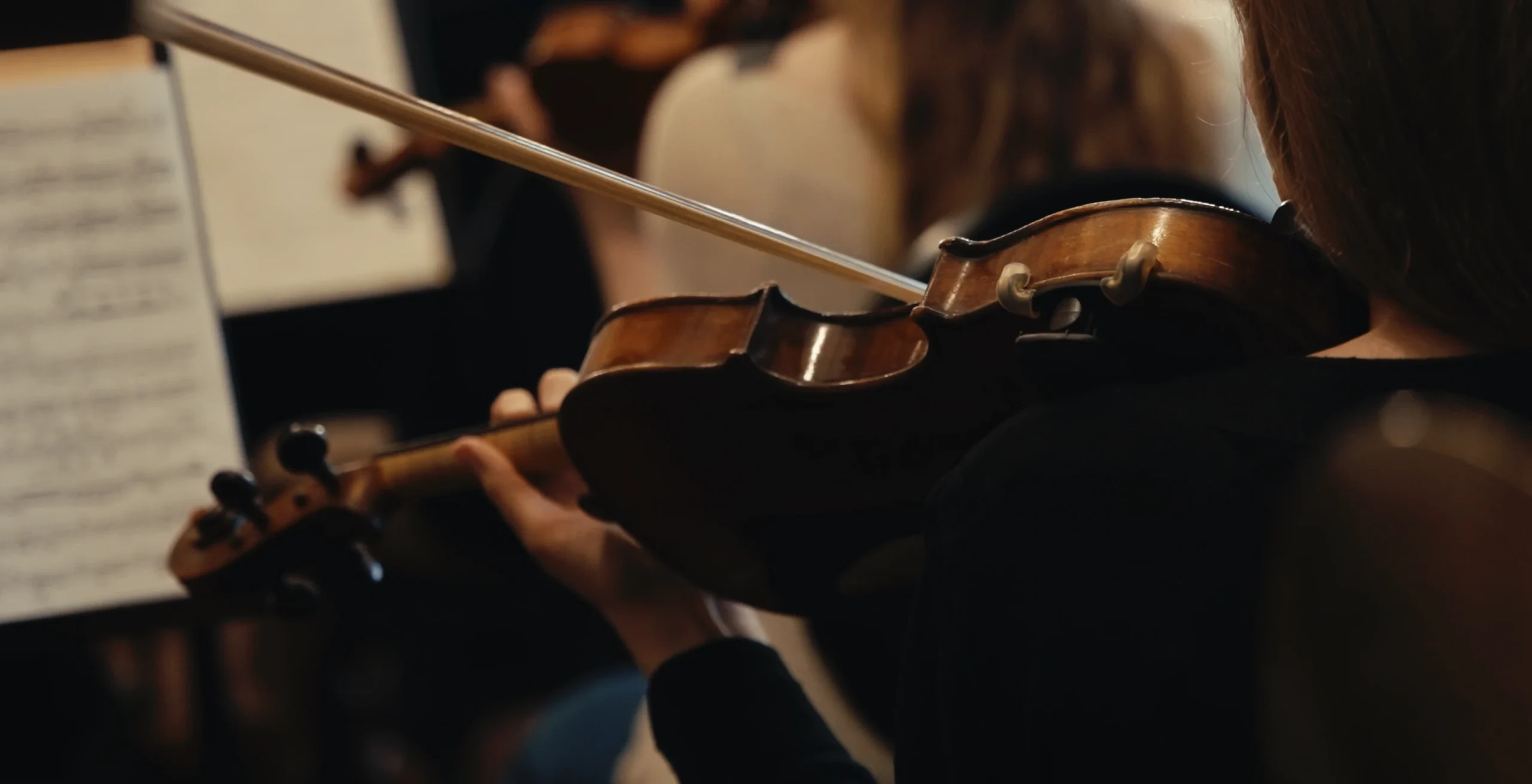 Viulisti soittamassa orkesterissa